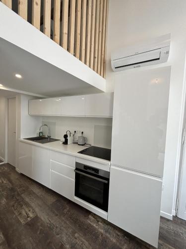 une cuisine blanche avec un évier et une cuisinière dans l'établissement LEA T3 Victor Hugo Clim Hypercentre, à Grenoble