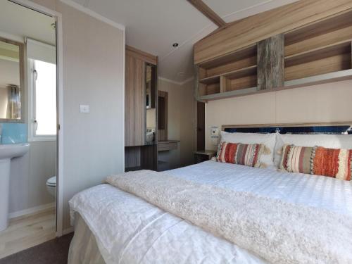 a bedroom with a large bed and a bathroom at Golden Sands beach activities sea holiday relax in Mablethorpe