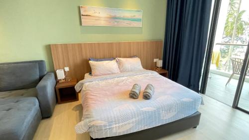 een slaapkamer met een bed met een paar schoenen erop bij Freedom Flamingos-RoxyBeachApt in Sematan