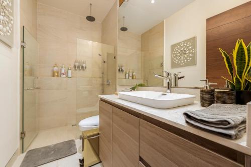卡波圣卢卡斯Luxury condo with pool, jacuzzi, and private terrace的带水槽和淋浴的浴室