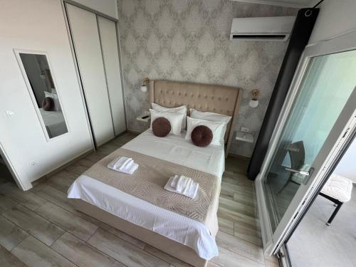 a bedroom with a white bed with two pillows at B&B Bloom Apartments in Vir