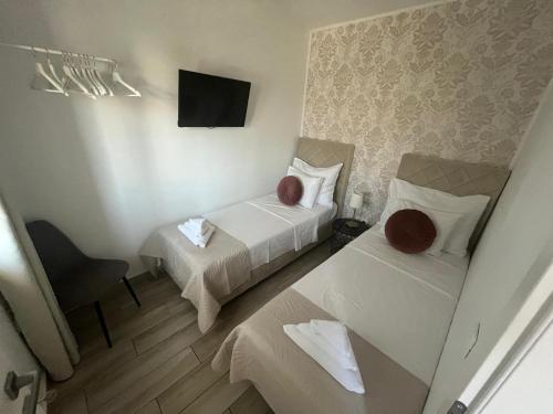 a hotel room with two beds and a television at B&B Bloom Apartments in Vir