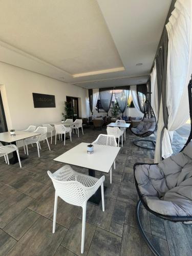 a room with white tables and chairs and tables and chairs at B&B Bloom Apartments in Vir