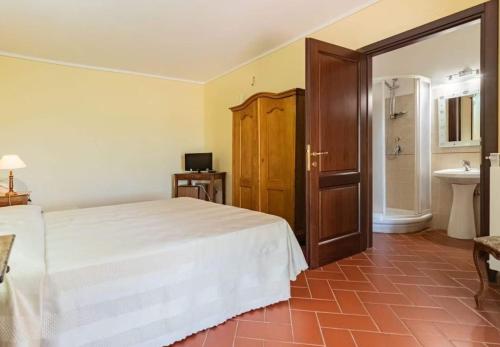 a bedroom with a white bed and a sink at Il Girasole Terzuolo in Manciano