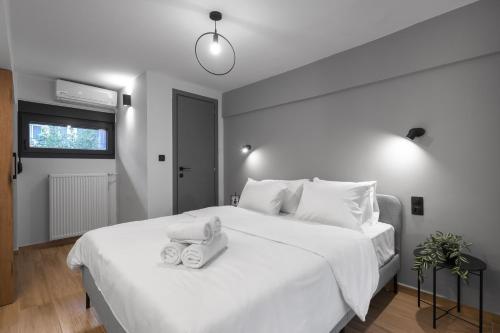 a bedroom with a large white bed with towels on it at Railway Lofts in Thessaloniki