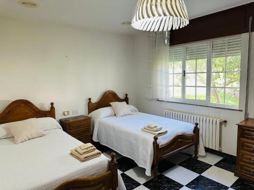 a bedroom with two beds and a chandelier at Casa de Meruso in San Pedro
