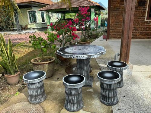 a stone table with four stools around it at HOMESTAY WARISAN BENTONG in Bentong