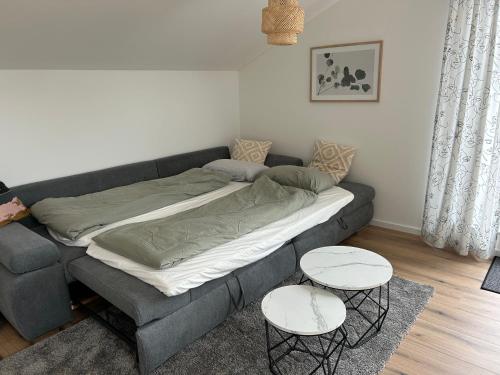 a bed in a living room with two tables at Ferienwohnung Sonnendeck in Kranenburg
