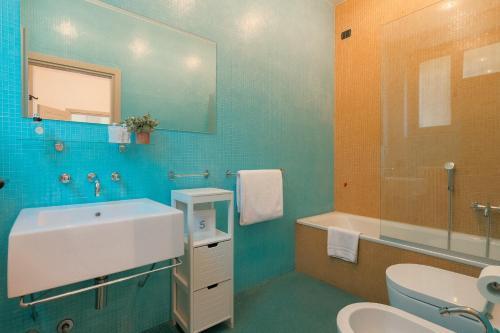 a bathroom with a sink and a toilet and a mirror at Villa Locana con Jacuzzi e vista lago in Laglio