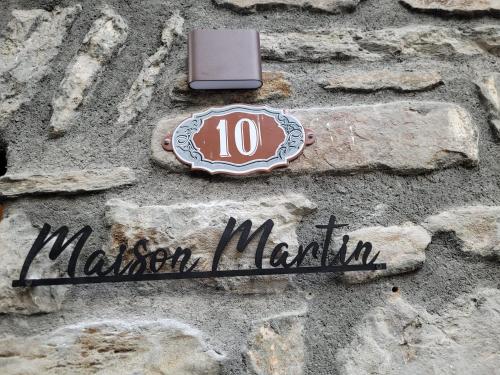 a sign on the side of a stone building at Maison Martin in Pré-Saint-Didier