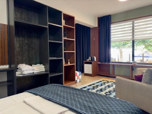 a bedroom with a bed and a couch and a window at Orb Inn in Sarandë