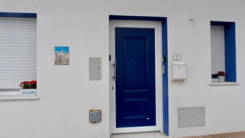 a blue door on the side of a building at Sa Caletta Appartamenti in Portoscuso