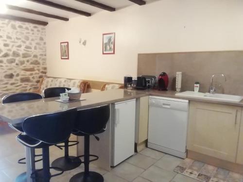 une cuisine avec un comptoir et quelques tabourets de bar dans l'établissement High Mill Lake - Etang de Brigueuil, à Brigueuil