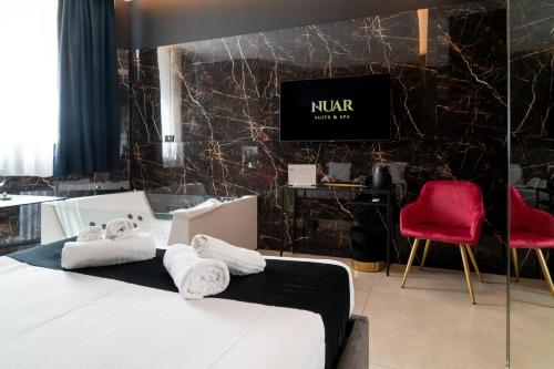 a bedroom with a bed and two red chairs at Nuar suite&spa in Palermo