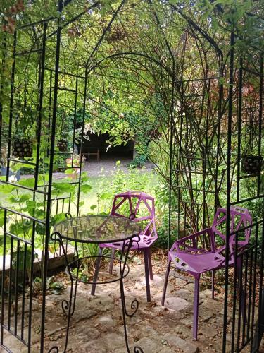 two purple chairs and a table in a garden at Chambre d'hôte dans manoir près du Tréport et Mers-les-Bains in Gamaches