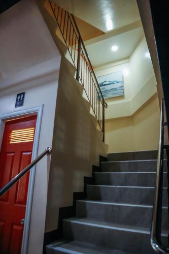 a staircase with a red door in a building at Citistyle Inn in Davao City