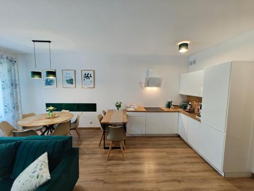 a kitchen and living room with a table and a kitchen and a dining room at Domek Zielone Marzenie in Chrzanów