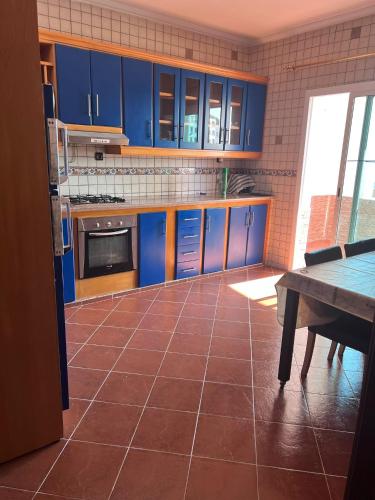 cocina con armarios azules y suelo de baldosa en Complexe tarifa, en Tánger
