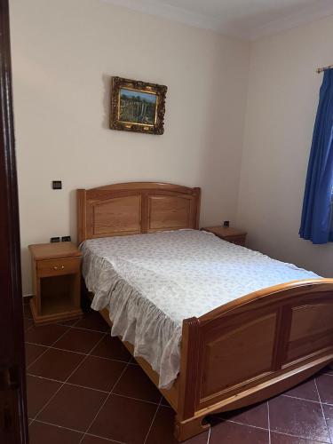 Un dormitorio con una cama y un cuadro en la pared. en Complexe tarifa, en Tánger