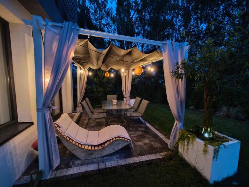 a backyard with a gazebo with a table and chairs at Domek Zielone Marzenie in Chrzanów