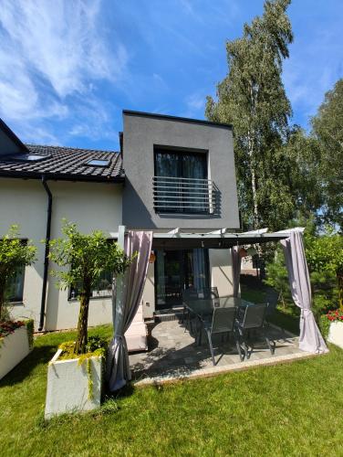 a house with a patio with chairs in the yard at Domek Zielone Marzenie in Chrzanów
