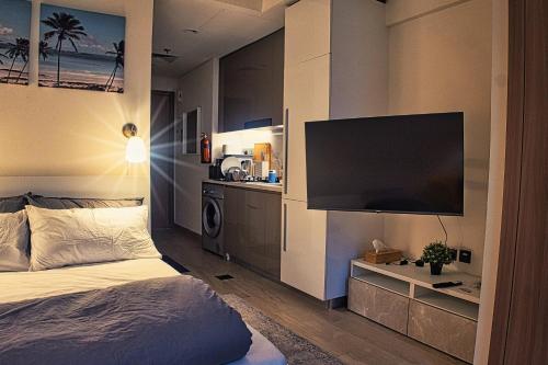 une chambre avec un lit et une télévision à écran plat dans l'établissement Stylish Studio Retreat, à Dubaï