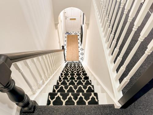 an ascending staircase with black and white carpeted stairs at Pass the Keys City Convenience in Stanley