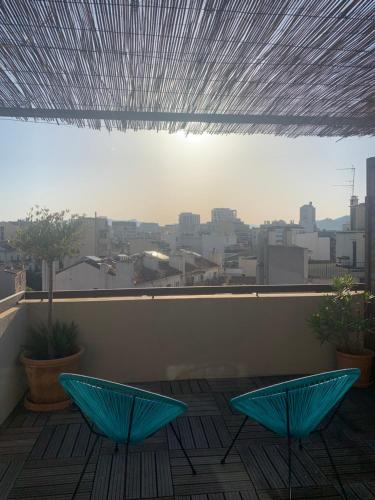 - deux chaises bleues sur un balcon avec vue sur la ville dans l'établissement Joli appartement avec belle terrasse, à Marseille