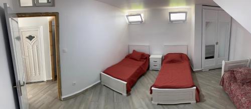 a small bedroom with two beds and a mirror at Logement spacieux 10personnes - Location Azeffoun Ait Chafaa-11000da in Azeffoun