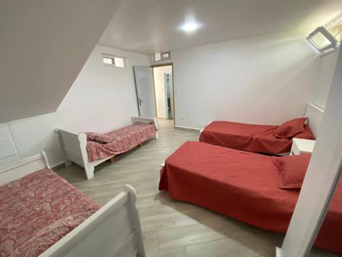a room with two beds and a couch in it at Logement spacieux 10personnes - Location Azeffoun Ait Chafaa-11000da in Azeffoun