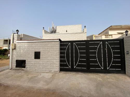 a black gate in front of a building at Logement spacieux 10personnes - Location Azeffoun Ait Chafaa-11000da in Azeffoun
