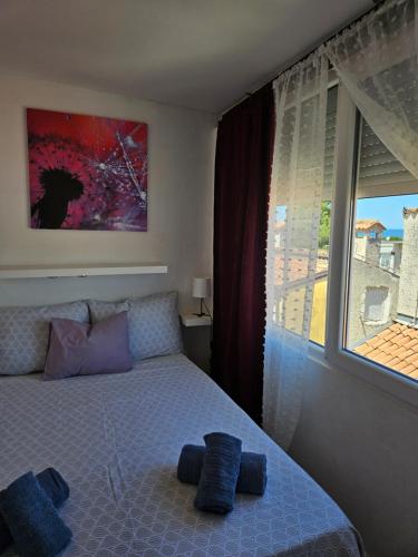 a bedroom with a bed with blue pillows and a window at Pipo Apartment Mareda in Novigrad Istria