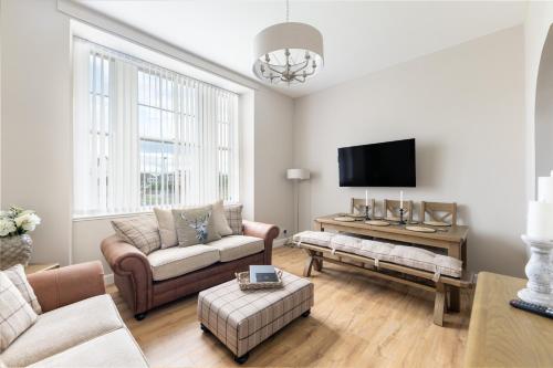 a living room with a couch and a tv at Old Edinburgh Court in Inverness