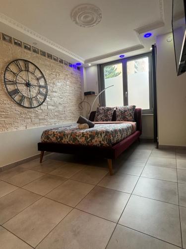 un salon avec un canapé et une horloge au mur dans l'établissement Just cozy lille, à Lille