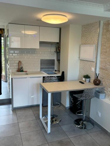 une cuisine avec des armoires blanches et une table en bois dans l'établissement Just cozy lille, à Lille