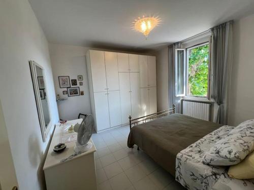 ペーザロにあるCasa Vacanze Tina centro Pesaroのベッドとドレッサーと窓のある寝室