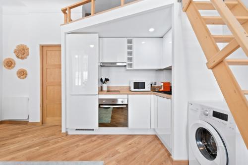 une cuisine avec des armoires blanches et une laveuse et une sécheuse dans l'établissement Nice Renting - 5bFRANCE - Luxurious Apartment Place Massena Promenade des Anglais, à Nice