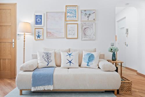 - un salon avec un canapé et des oreillers bleus et blancs dans l'établissement Nice Renting - 5bFRANCE - Luxurious Apartment Place Massena Promenade des Anglais, à Nice