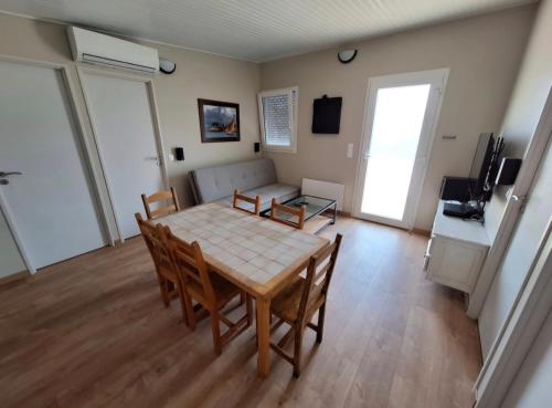 un salon avec une table, des chaises et un canapé dans l'établissement Maisonnette 40m2 type mobil-home, à Saint-Vit