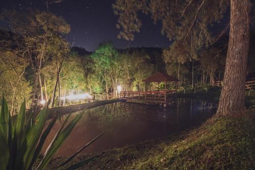 a bridge over a body of water at night at Cabanas dos Plátanos in Gramado