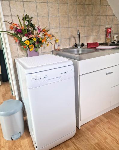 une cuisine avec un réfrigérateur blanc et un évier dans l'établissement Studio à la campagne proche de Honfleur, à Saint-Gatien-des-Bois