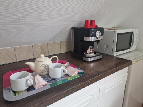 - un comptoir de cuisine avec 2 tasses et une cafetière dans l'établissement Studio à la campagne proche de Honfleur, à Saint-Gatien-des-Bois