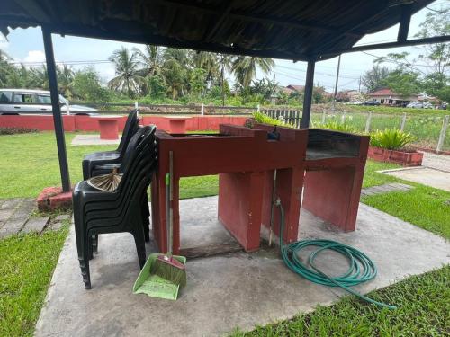 a red desk with two chairs and a hose at The SeaShell Chalet Melaka Kuala Sg Baru in Kampung Kuala Linggi