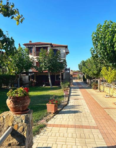 a walkway in front of a house with potted plants at Villa Maron - Platanitis Beach in Maronia