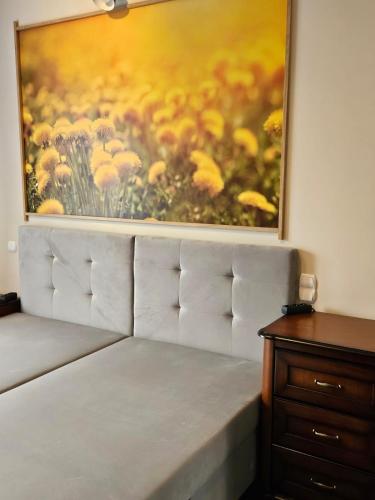 a painting on the wall above a bed in a room at Noclegi -Chata Polska in Chrostkowo