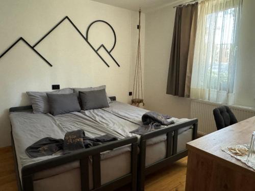 a bedroom with a bed with mountains on the wall at Vila Aspen - Mountain View Apartments in Delčevo