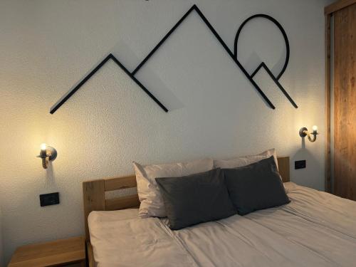 a bedroom with a bed with a picture of mountains on the wall at Vila Aspen - Mountain View Apartments in Delčevo