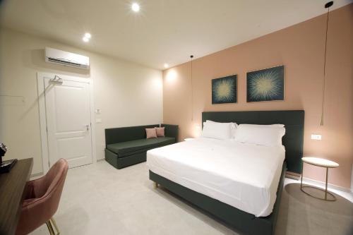 a bedroom with a large white bed and a couch at Sebèl Camere di Charme in Barletta