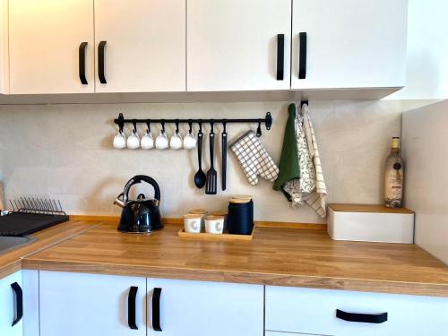 a kitchen with white cabinets and a wooden counter top at Košutica Vila in Koraćica