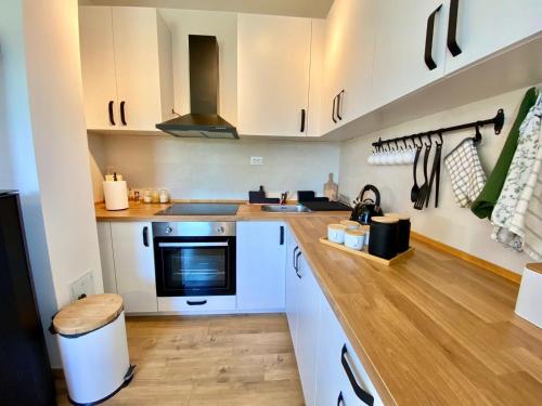 a kitchen with white cabinets and a wooden counter top at Košutica Vila in Koraćica